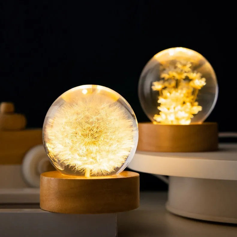 Preserved dandelion inside a glowing resin crystal ball night light on a beech wood stand.