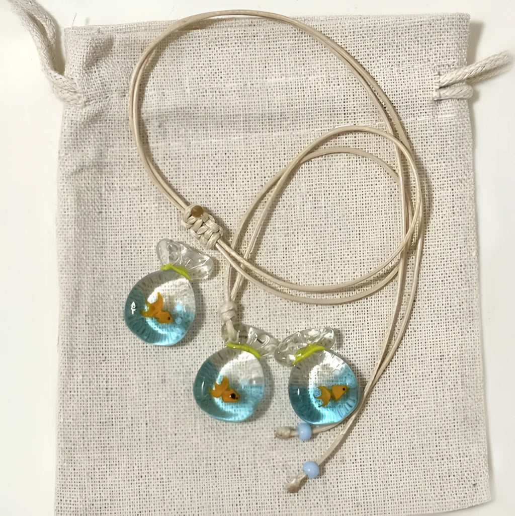 Women's necklace with coloured glaze joker pendant on a woven cotton and linen clavicle chain.