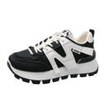 Unisex low-top sneaker in black with round toe, flat heel, and lace-up front on a rubber sole.