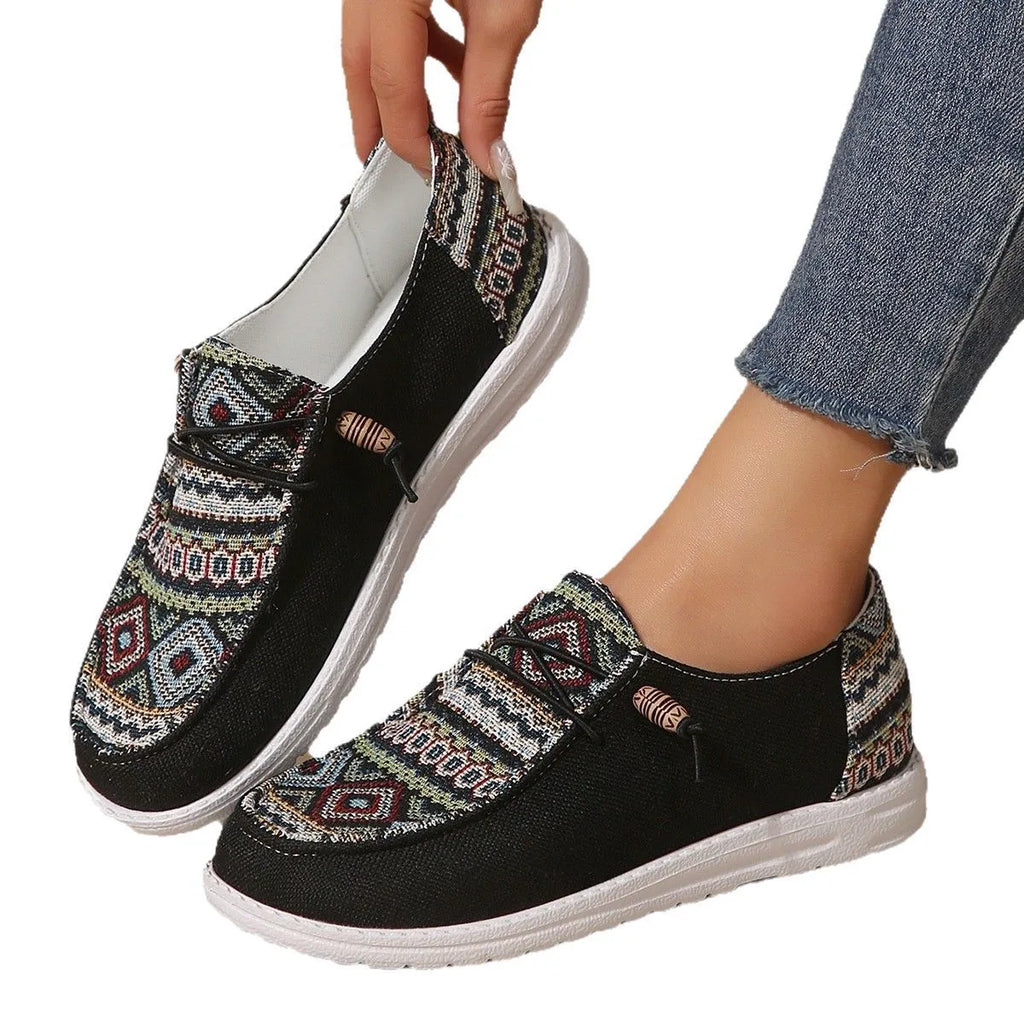 Women's flat slip-on shoes in black with round toe and rubber sole on a white background