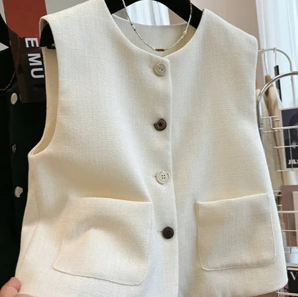 Woman wearing a milky white sleeveless bandage vest dress with a round neckline.