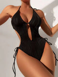 Women's black triangle bikini with white lace-up fastening detail on the front