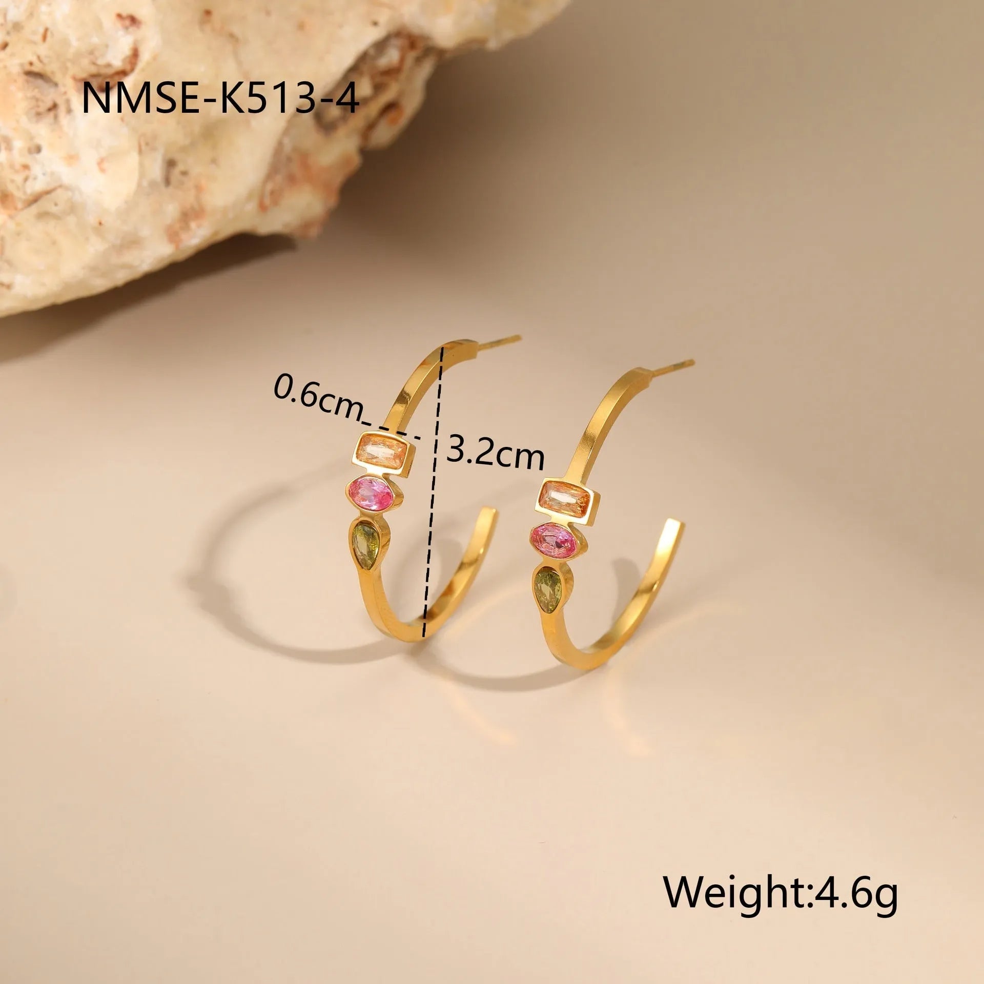 Geometric gold plated zircon necklace, ring, and earrings set on a plain background