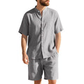 Man wearing a light blue linen blend Henry collar short sleeve suit top with matching shorts.