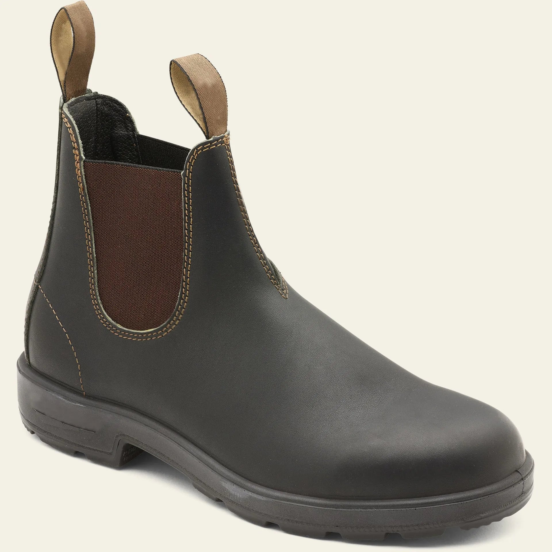 Vintage brown frosted finish Chelsea boots with car suture detailing on a wooden floor.