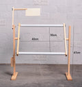 Vertical solid wood cross stitch frame on a desktop, showing adjustable height and pine construction.