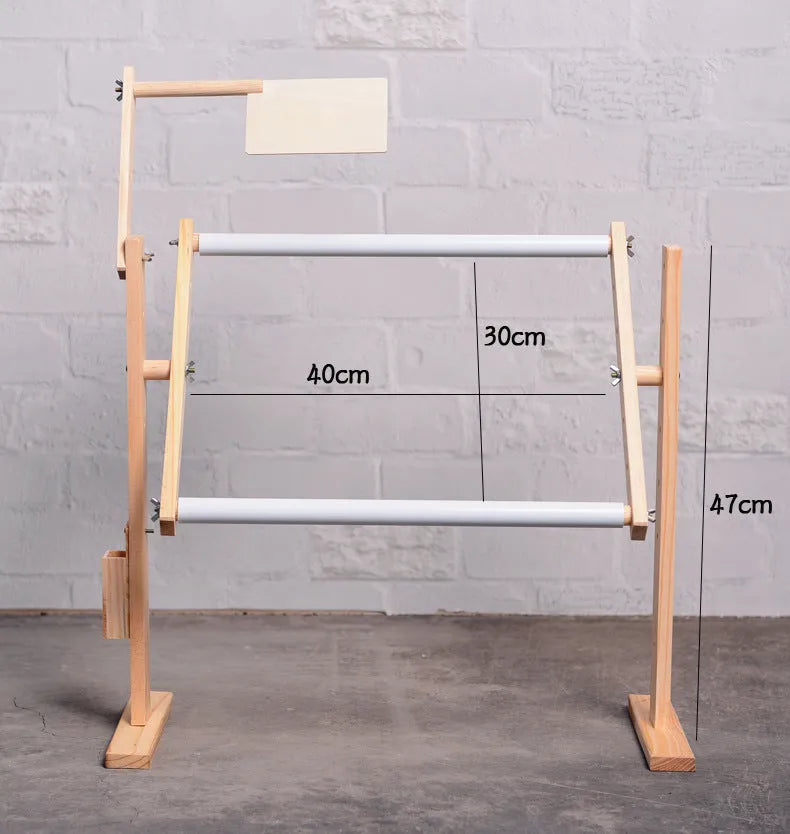 Vertical solid wood cross stitch frame on a desktop, showing adjustable height and pine construction.