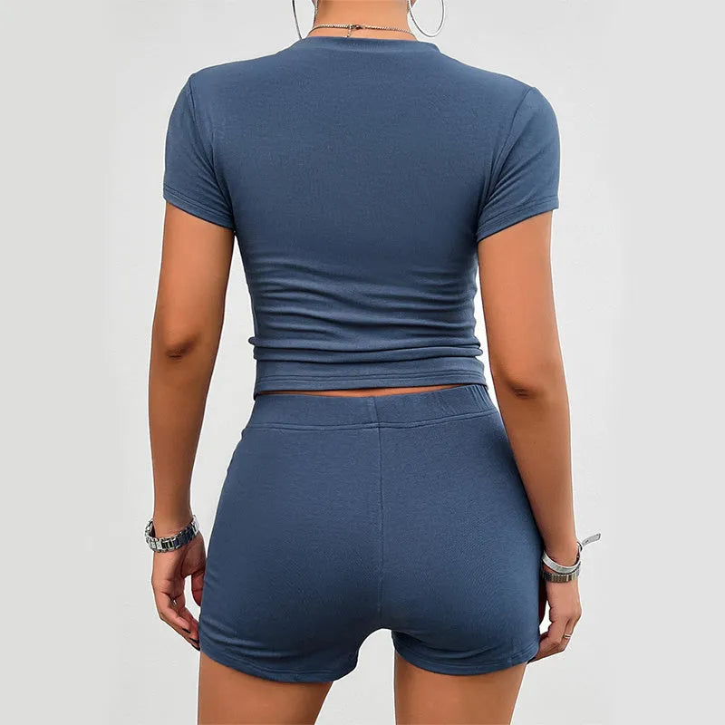 Women's solid colour slim fit sports suit set with short sleeve t-shirt and elastic shorts.