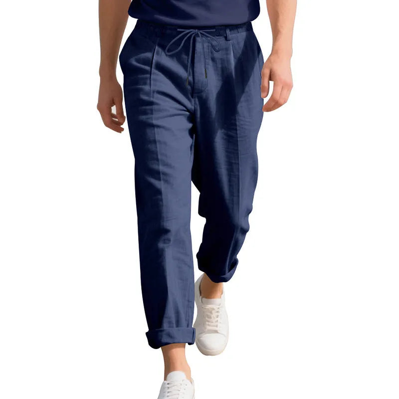 Men's light khaki linen casual trousers with drawstring waist and straight loose leg on hanger.