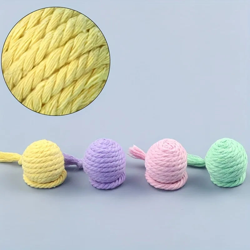 Green cat toy ball with a rope handle looped through it, shown next to a smaller pink version.