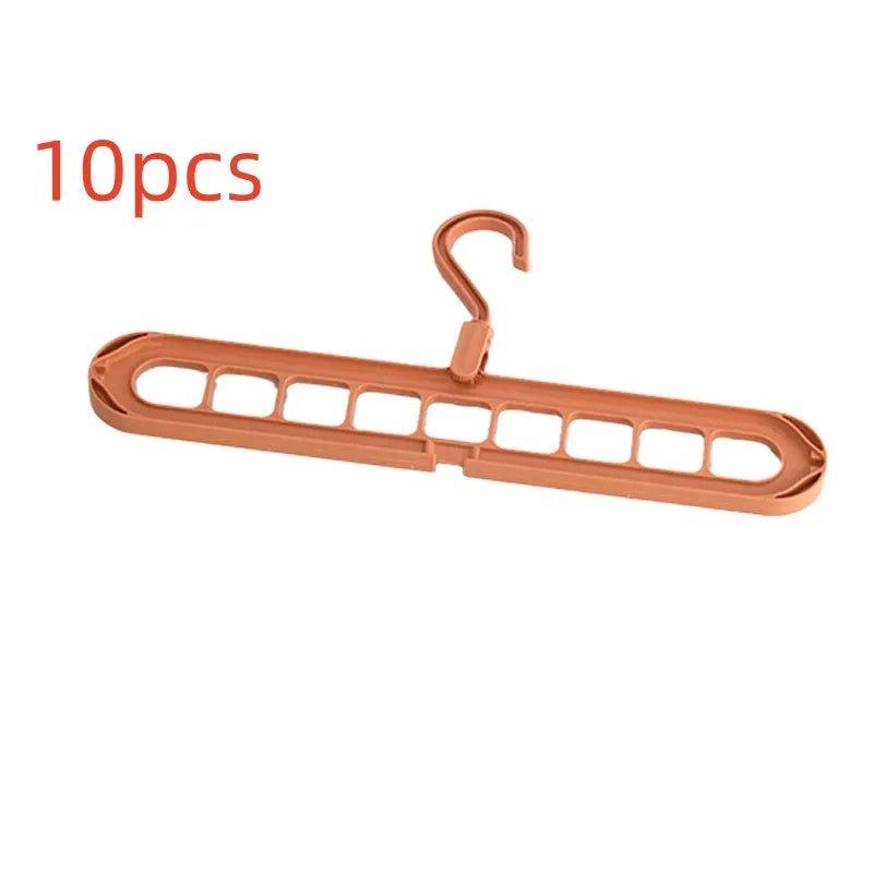 Green plastic nine-hole folding trouser hanger showing multiple trousers hung