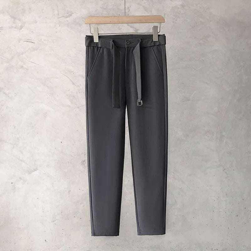 Boy wearing slim straight grey wool trousers with a tapered fit and straight leg opening.