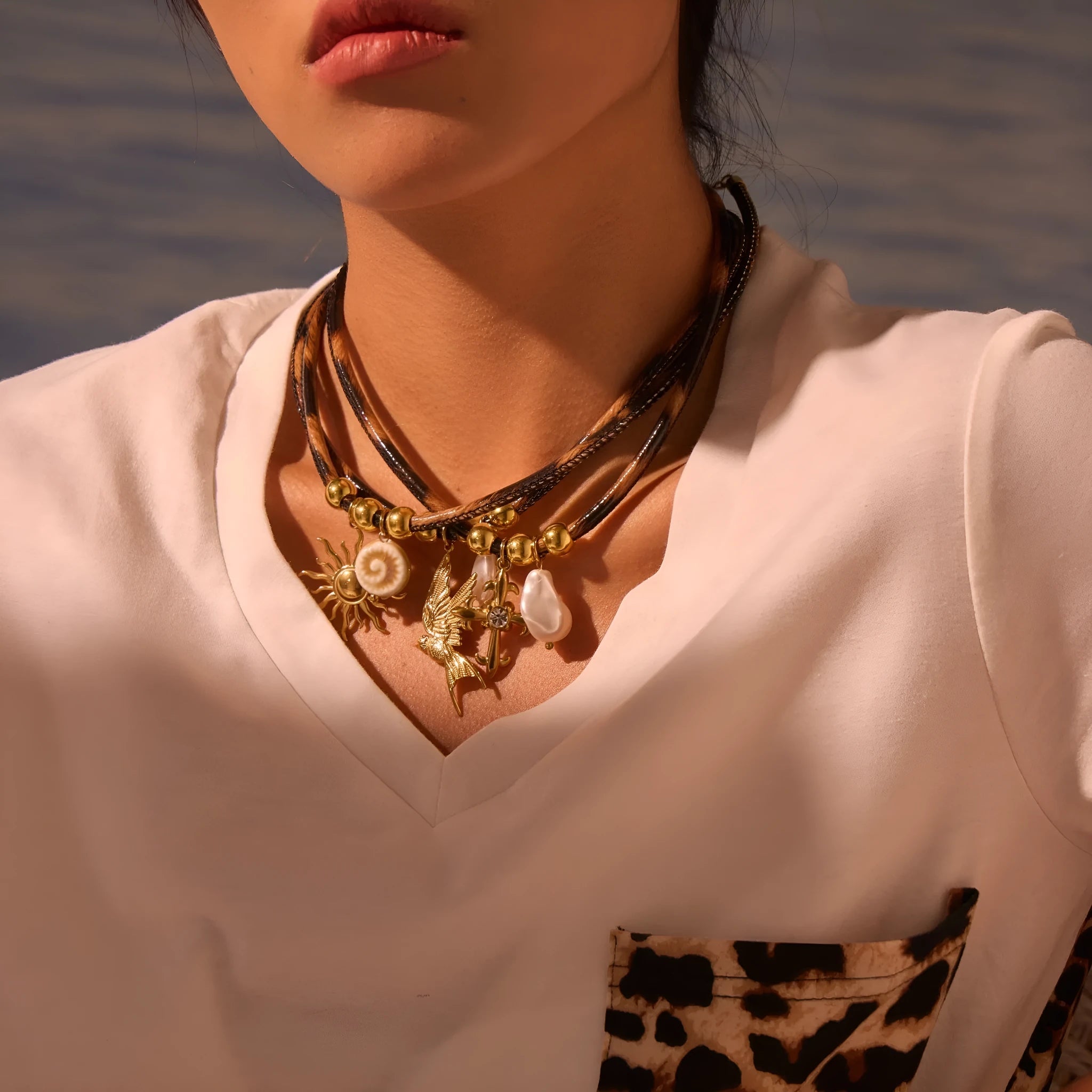 Gold plated stainless steel necklace with geometric leopard pendant and adjustable chain on white background