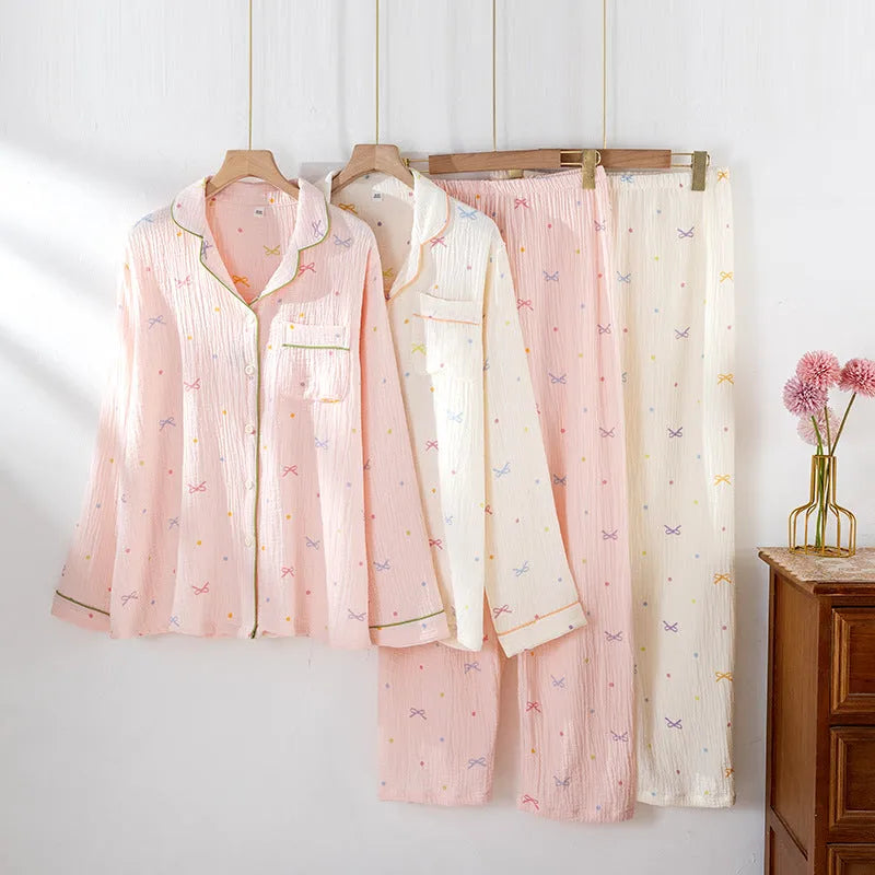 Women's pink cotton long sleeve pajama top and trousers set on hanger.