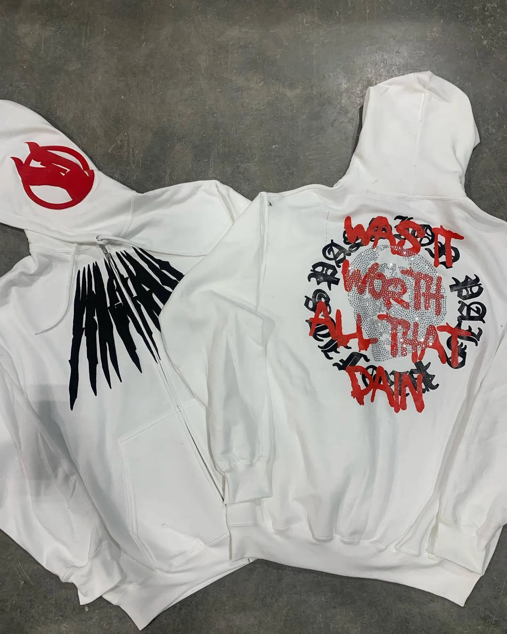 Black loose hooded sweatshirt with white printed skull and rhinestone design, showing cardigan style and long sleeves.