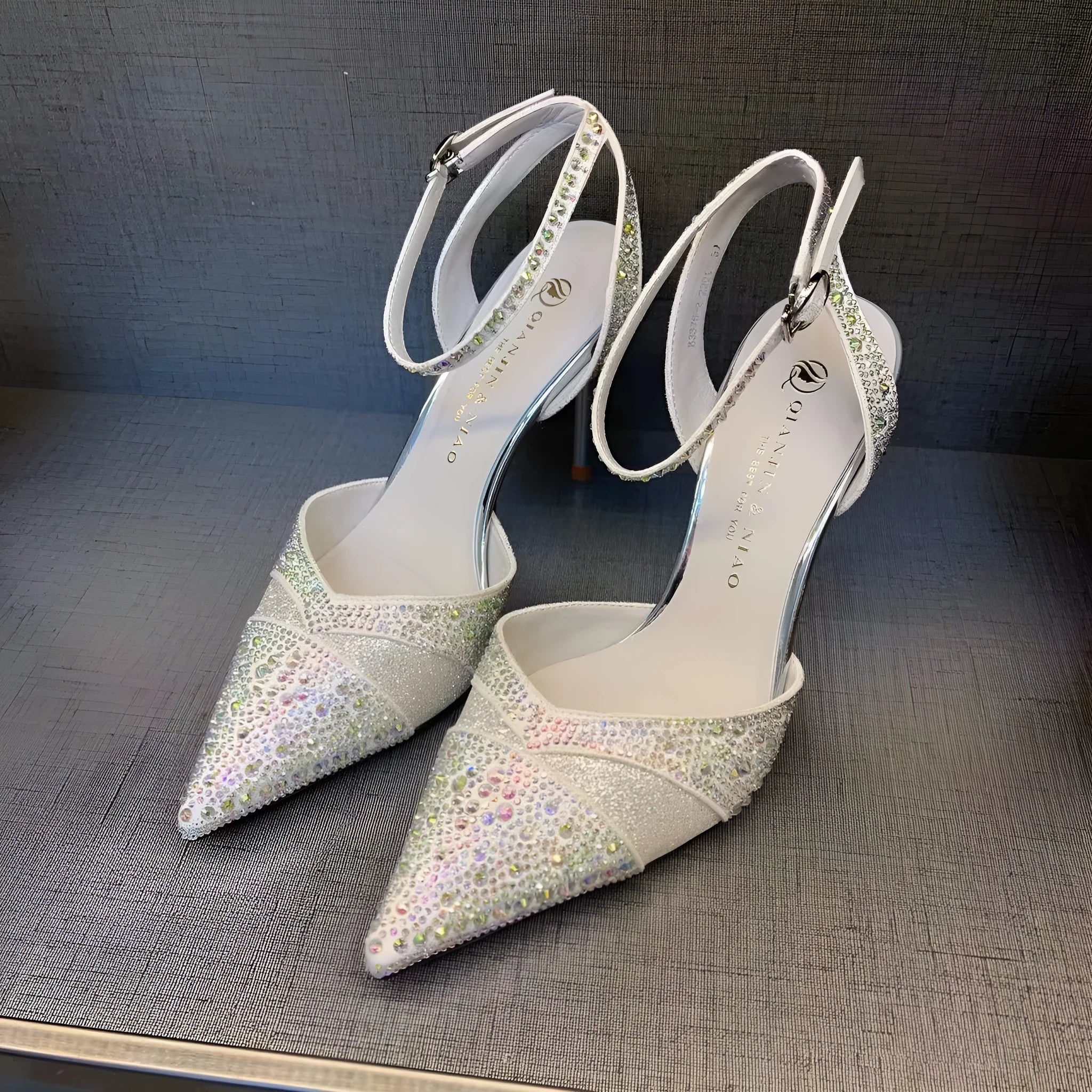 Women's black hollow cut stiletto high heels with pointed toe and red sole on a white background