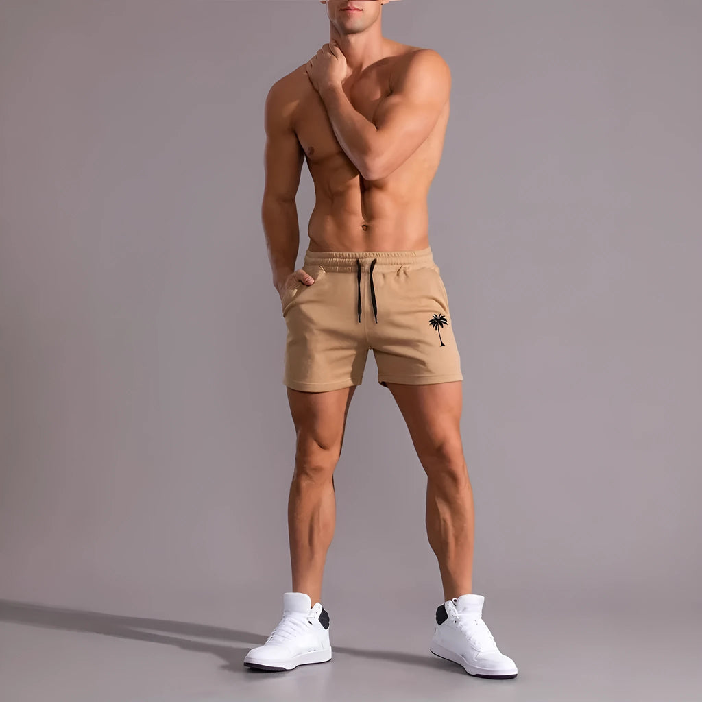 Khaki men's sports shorts with a white coconut leaf print, showing straight leg fit.
