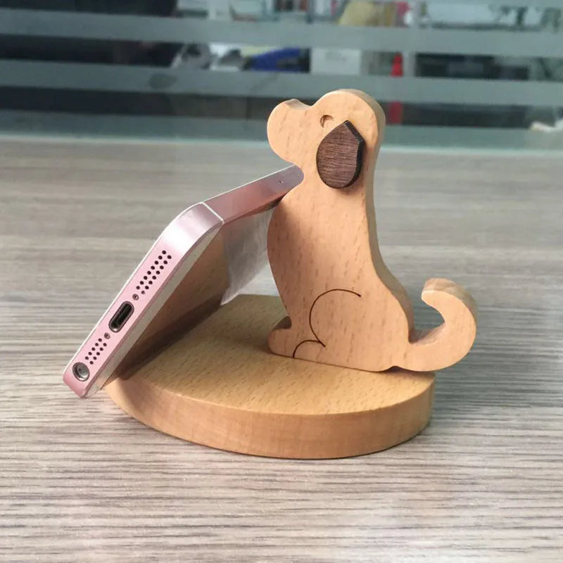 Beech wood and resin mobile phone holder bracket in a decorative animal design on a desk.