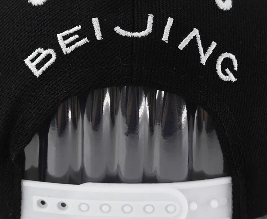 Cotton baseball cap with letter embroidery in black colour showing adjustable strap
