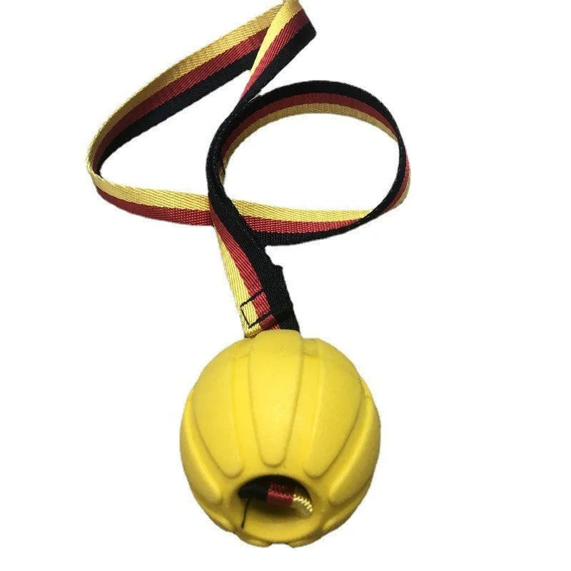 Floating EVA tetherball dog toy in yellow with attached retrieval string on water surface
