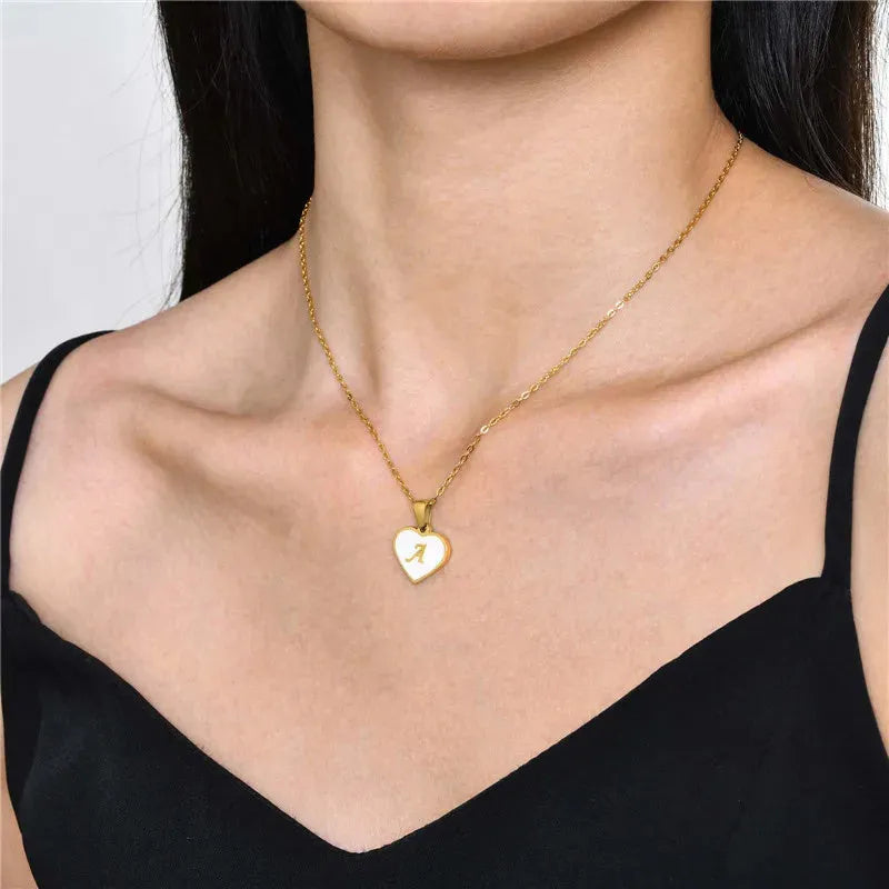 Gold chain necklace with white shell heart pendant featuring single letter customisation option