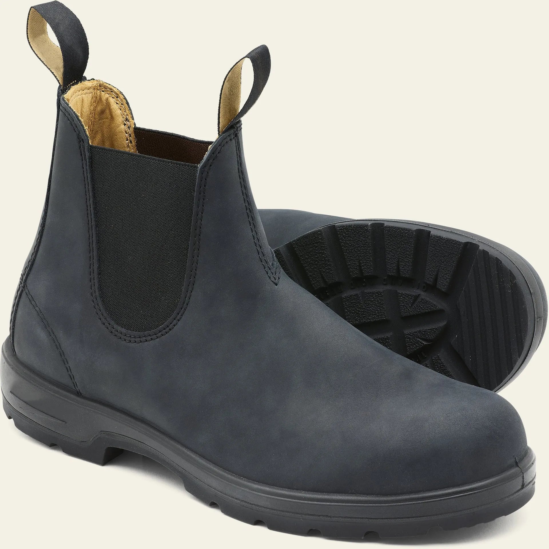 Vintage brown frosted finish Chelsea boots with car suture detailing on a wooden floor.