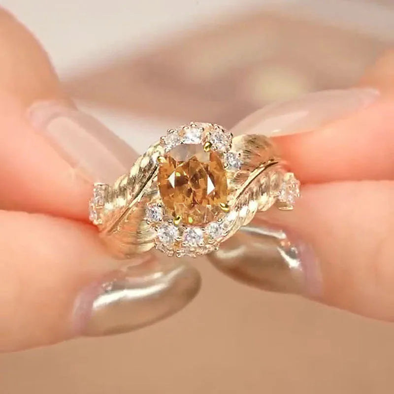 Gold-coloured copper ring with embossed feather pattern and yellow zircon stone