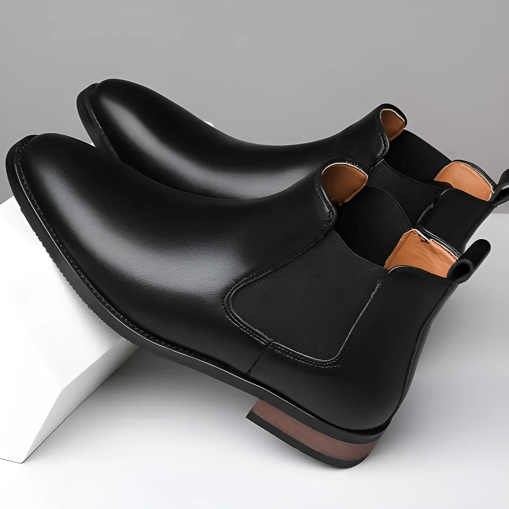 Men's black Chelsea boots with round toe, low heel, and mid-calf shaft made from artificial PU leather