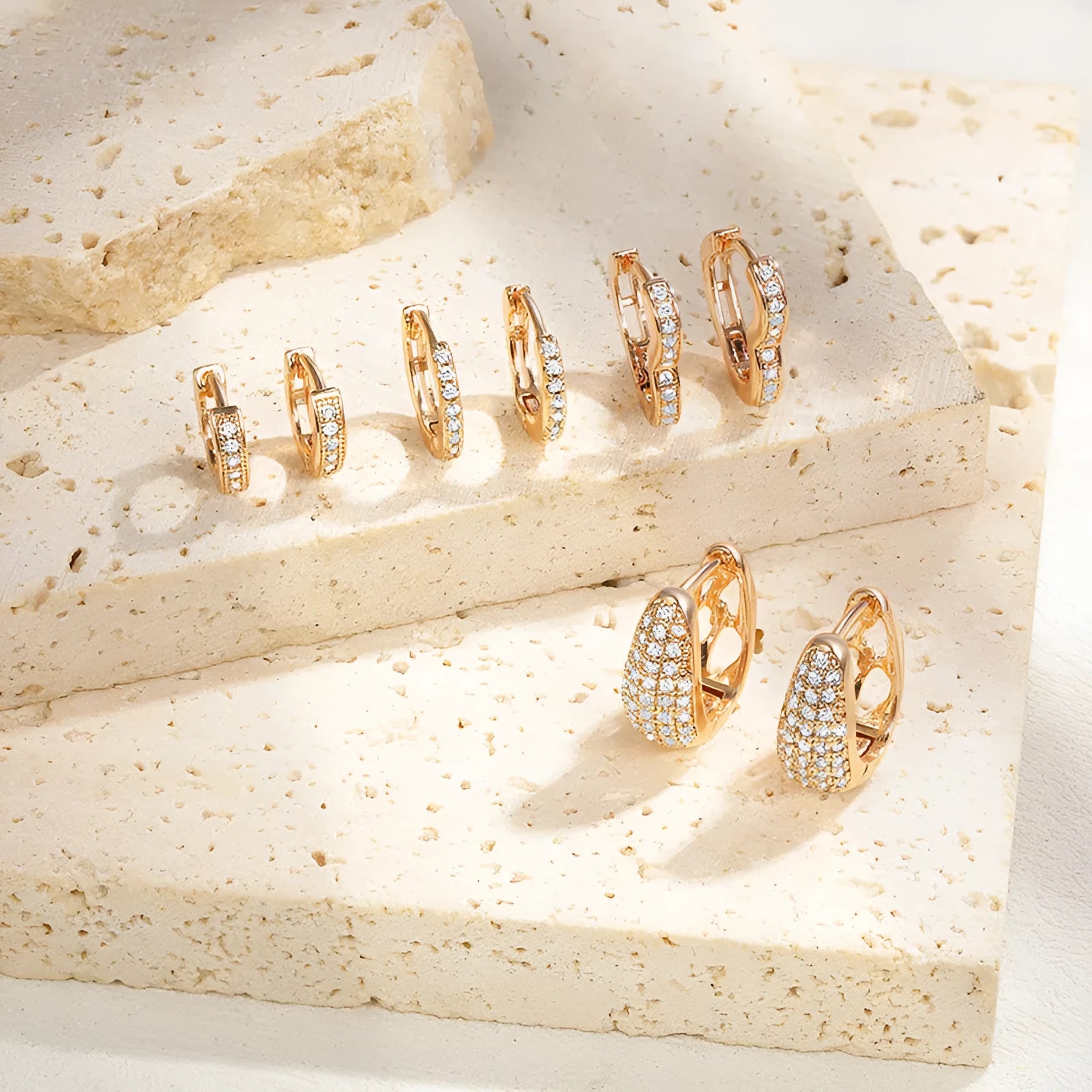 A pair of heart-shaped clip earrings with a single zircon stone in electroplated brass gold.