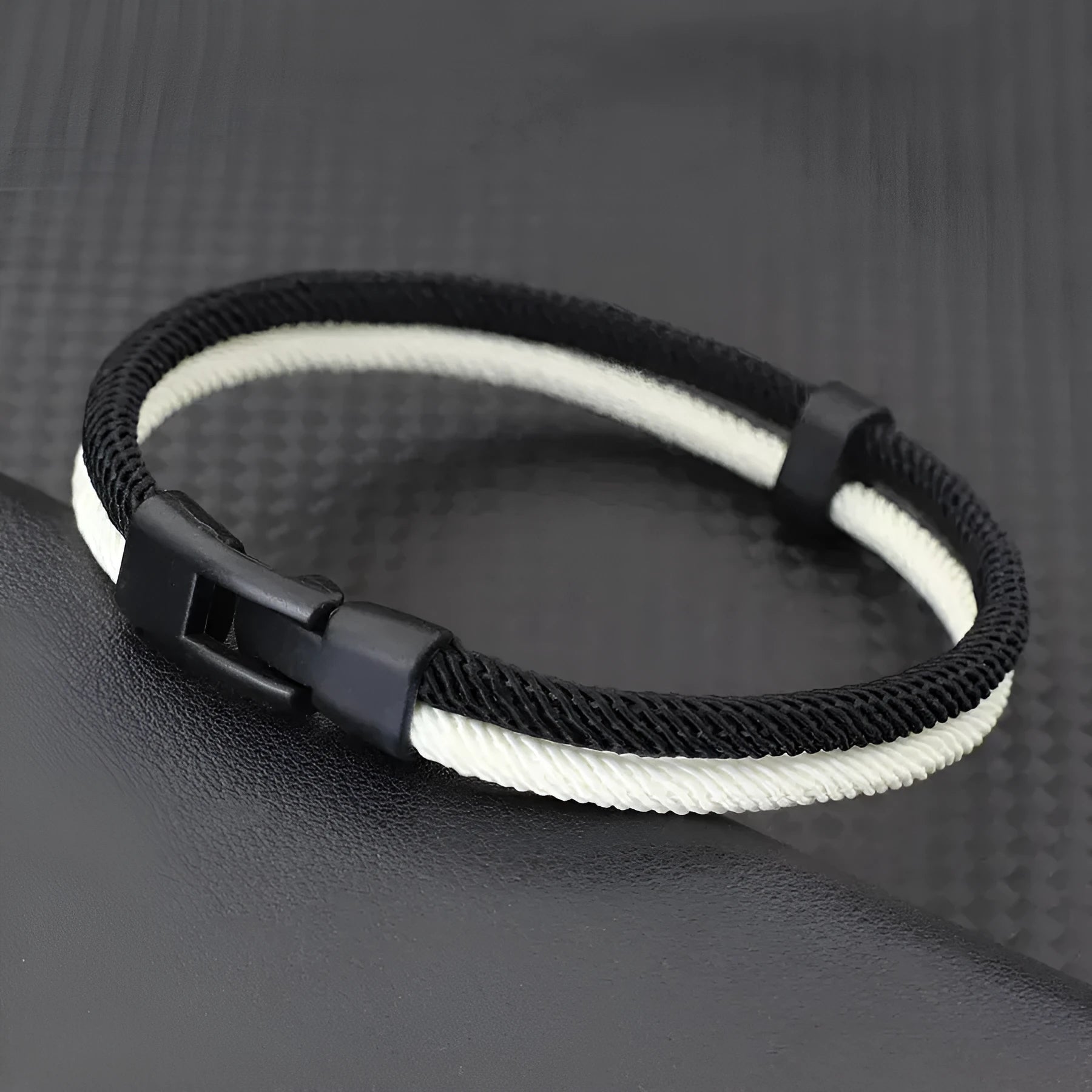 Black and white handmade woven hand strap made from Milan rope alloy showing textured surface